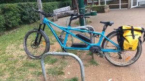 A tandem bike leaning on a secure Sheffield type bike rack